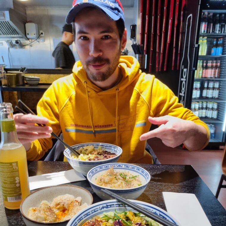 Jeff, der Autor dieses Artikels, sitzt in einem modern eingerichteten Restaurant. Er deutet auf einige Schalen mit chinesischen Nudelgerichten, die vor ihm auf dem Tisch stehen.
